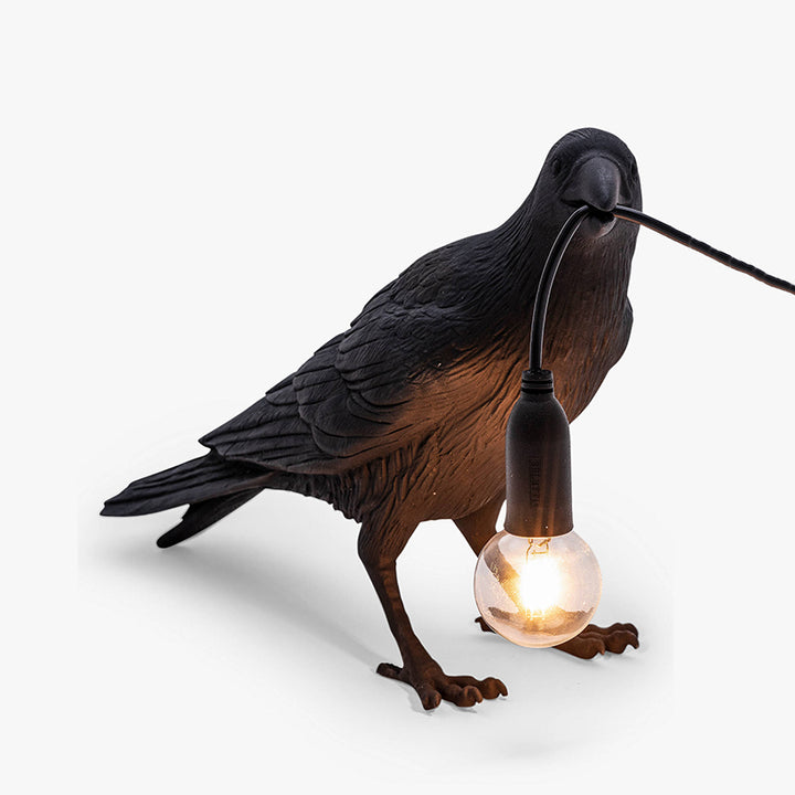 A close-up of the Raven Lamp's base, which features a striking raven perched on a branch.